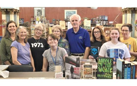SMT photo/Sara Eisinger.  Friends of the Marianna Black Library volunteers Patricia Gott (front, center); (middle, left to right) Carolyn Allison and Rilyn  Anderson; (back, left to right) Joia Goforth, Marcia Mycko, Helen Holman, Monte Dunten, Hannah Anderson and Deanna Booth get together at Friends of the Marianna Black Library Used Bookstore on Everett Street July 27. The bookstore is 100% run by dedicated volunteers.