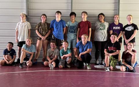 Submitted photo.  Logan Mantz (front, left to right), Andi Allen, Gus Ball, Tiegen Smith, Makayla Hunt, Mateo Mantz, Sawyer Norton; (back, left to right) Landon Mantz, Shaylee Temple, Caiden Vick, Seaborn Bradley, Connor Walls, Alexis Tranter, Elli Norton and Claire Ball practice at DeHart Wresting Academy in May. Some will participate in the DeHart Wrestling Academy Mountain Intensive Camp July 9-13.
