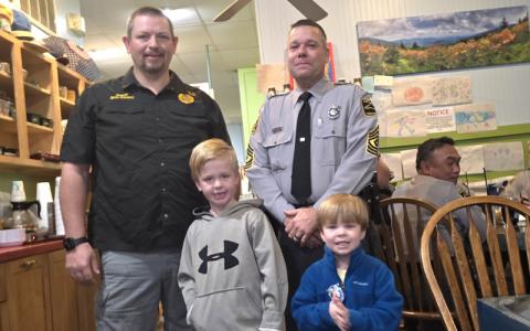 SMT photo/Sara Eisinger.  Sutton (front, left to right) and Wyatt Williams meet Swain County Sheriff Brian Kirkland and NC State Highway Patrol 1st Sgt. Kevin Milligan at Everett Street Diner where local law enforcement celebrated National Faith & Blue Weekend Monday morning.