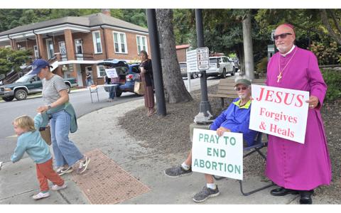 SMT photo/Sara Eisinger.  St. Joseph’s Roman Catholic Church parishioner Bob Burns holds a “Pray to end abortion” sign next to Right Reverend Bishop Denny Trousdale from St. Augustine’s Anglican Church during the National Life Chain demonstration in Bryson City, organized by Western Carolina Pregnancy Care Center, Oct. 5.