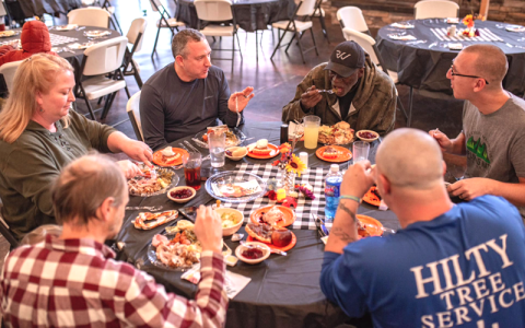 Photo/Lauren Waggoner.  The community and disaster relief victims enjoy a free Thanksgiving meal in the Volunteer Hall at Camp Living Water last November.