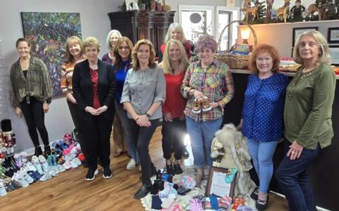 Photo/Sara Eisinger.   Alita Cunningham (front, left to right), Kaye McConnell, Jeannie Lerch, Marsha Sherrod; (middle, left to right) Tonya Clifton, Melissa barker, Terri Lynn Crider; (back, left to right) Nancy Jones, Candy Benton, Candy Wilson and Rhonda Tschida donate shoes and socks to kids in need at as part of a Shoes for Steps initiative headed by Swain County Resource Center to keep children’s feet warm this season at New Attitudes Hair Salon Friday, Nov. 7.