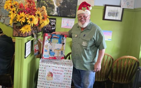 SMT photo/Sara Eisinger.  Mike Shakar, owner at Everett Street Diner, collects Christmas gifts in partnership with Swain County Family Resource Center Dec. 1 