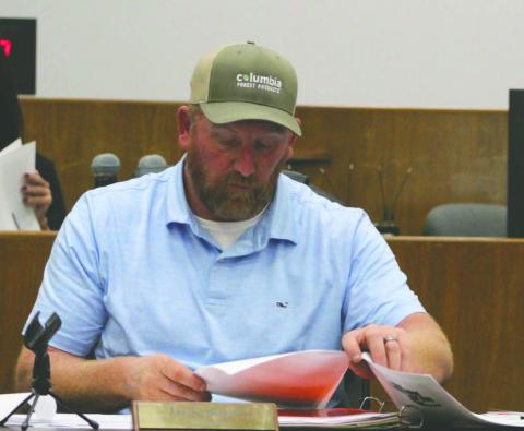 Press photo/Shelby Powell. Swain commissioner Jay Kirkland reviews a budget request made by the Swain County school board in a joint meeting between the two boards.