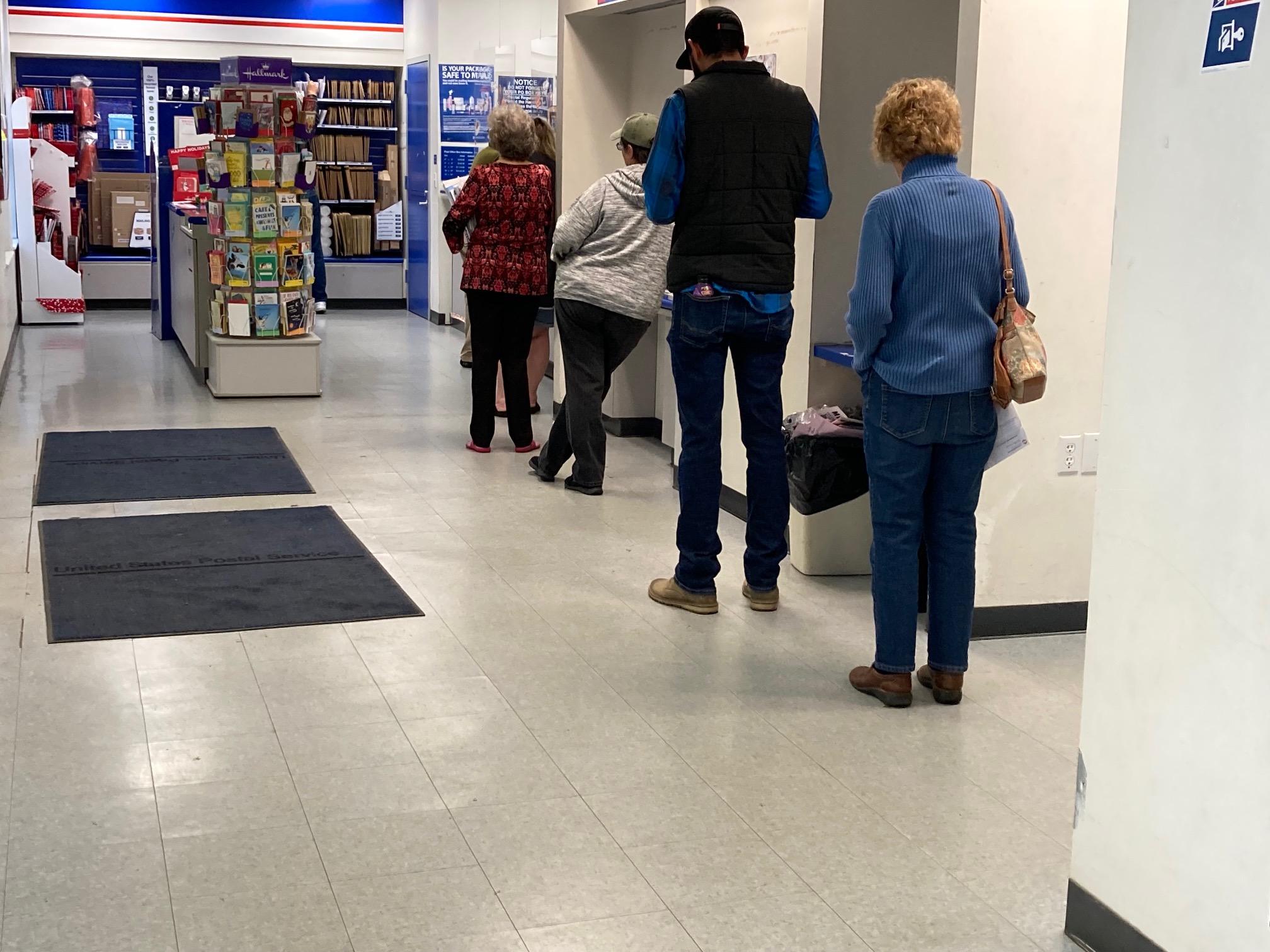 Customers wait in line at the Bryson City Post Office Monday.