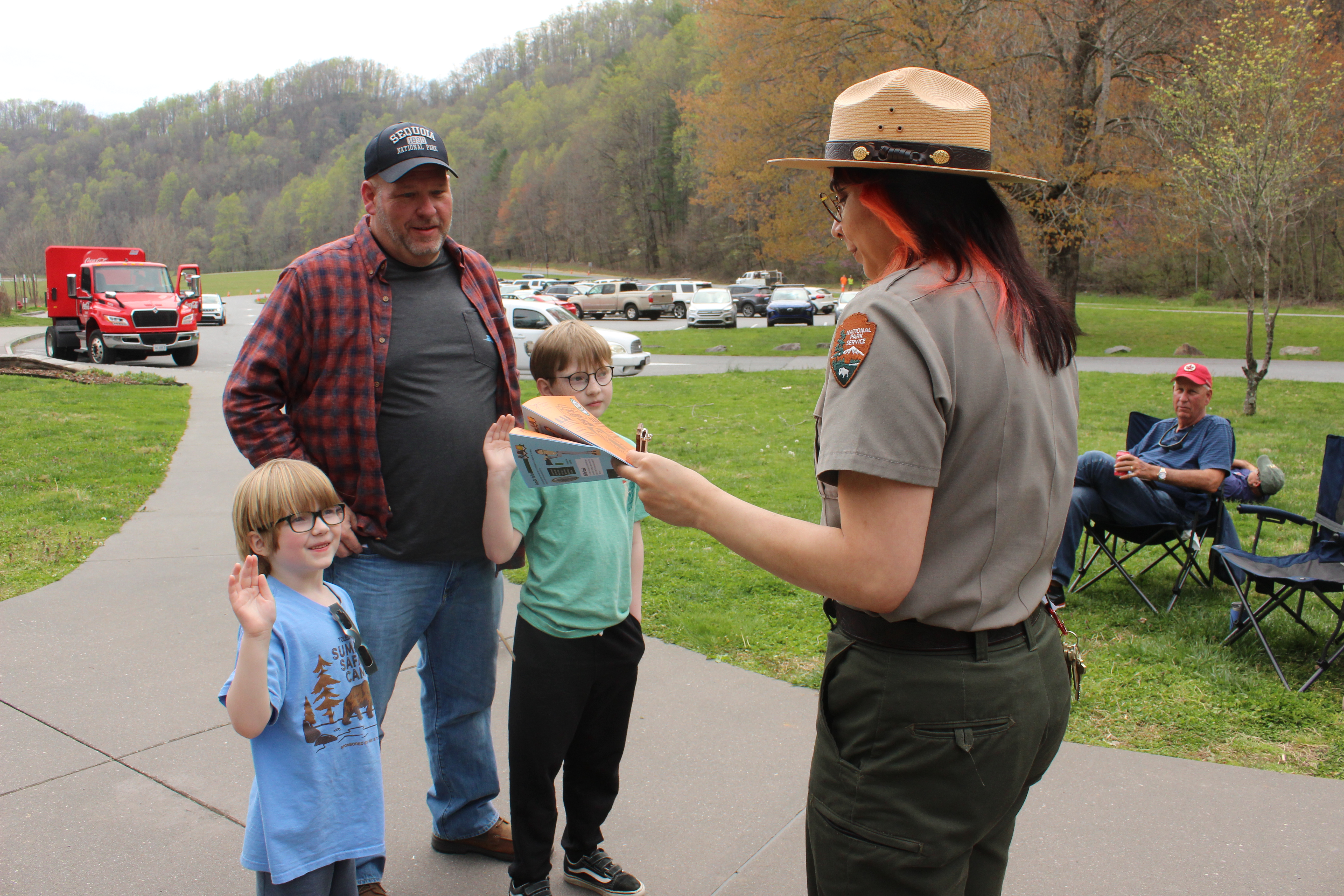 Park visitor Troy Guckiean’s sons are sworn into the Great Smoky Mountain National Park’s Junior Ranger program by park ranger Julie Flores. The boys, with hands raised, promised to only look at the eclipse using safe practices and protective eyewear.