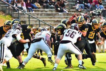 Swain’s Carson Taylor (32) Samuel Bernhisel (72) and Michael Winchester (56) defend the line against the Bulldogs.