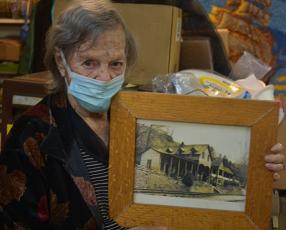 Juanita Lester holds a framed picture of her childhood home that was in the Bushnell community, one of several lost to the formation of Fontana Lake.