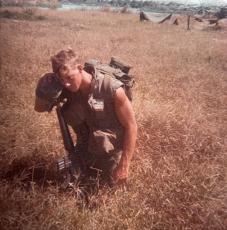Frank Jones is pictured in wartime in a field in Vietnam. 