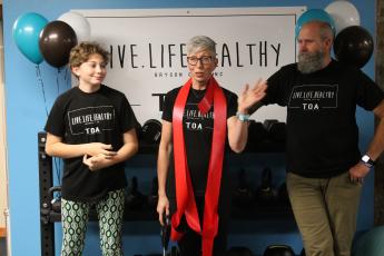 Shannon Royce, center, thanked her daughter Kenzie and husband Chris for all their help with opening her personal training studio, Live Life Healthy TOA,  during a ribbon cutting ceremony held Dec. 10. 