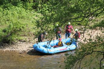 Swain County Swift Water Rescue Squad members rescue a woman who was stranded on an island on Tuckasegee River last Thursday after she and the man she was with waded into the water to evade law enforcement.