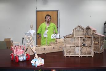Dustin Dyer is pictured with a toy tractor, sailing ship and two doll houses that he has constructed out of paper lunch bags and other limited materials available to him at the jail.