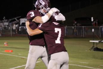 Josh Collins (from left) and James Stroman celebrate a touchdown at the game against the Cherokee Braves on Friday, Oct. 20, which the Maroon Devils won 45-7.