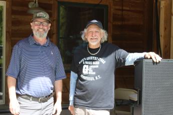 From left, Zach Thomason and Robin Fronrath work on Tuesday getting everything ready for the Sprang Thang musical festival to be held at Lands Creek Log Cabins Thursday-Saturday.