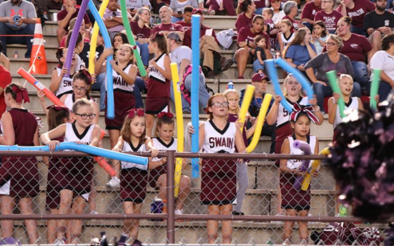 Fans at Swain football game including cheerleaders and fans with pool noodles