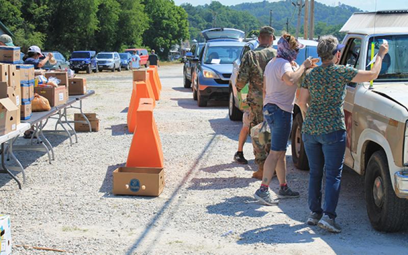 Volunteers give out boxes at the drive thru pop up market