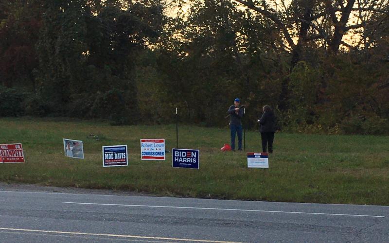 Democrats work to put up a large political sign across from Ingles