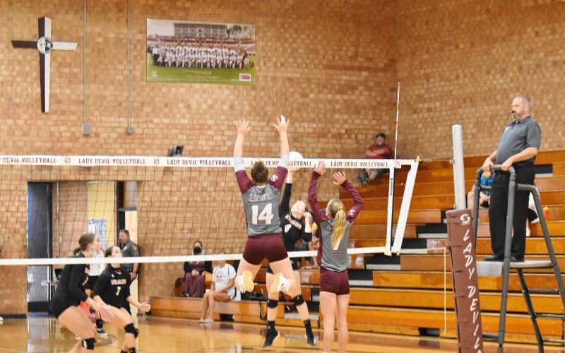 Lady Maroon Devils Savana Smith and Arizona Blankenship block an Andrews spike in the home loss against the Wildcats Thursday. 