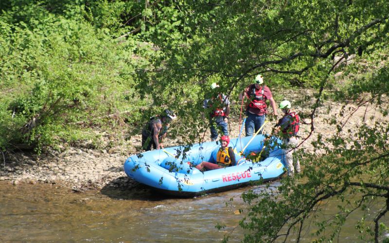Swain County Swift Water Rescue Squad members rescue a woman who was stranded on an island on Tuckasegee River last Thursday after she and the man she was with waded into the water to evade law enforcement.
