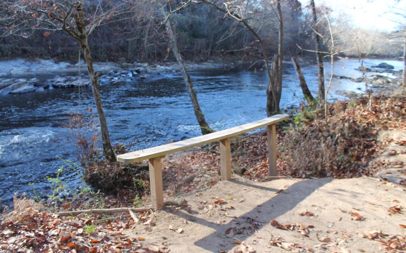 Erosion is obvious at this bench overlooking the river where the earth falls away at the edge of the bench.