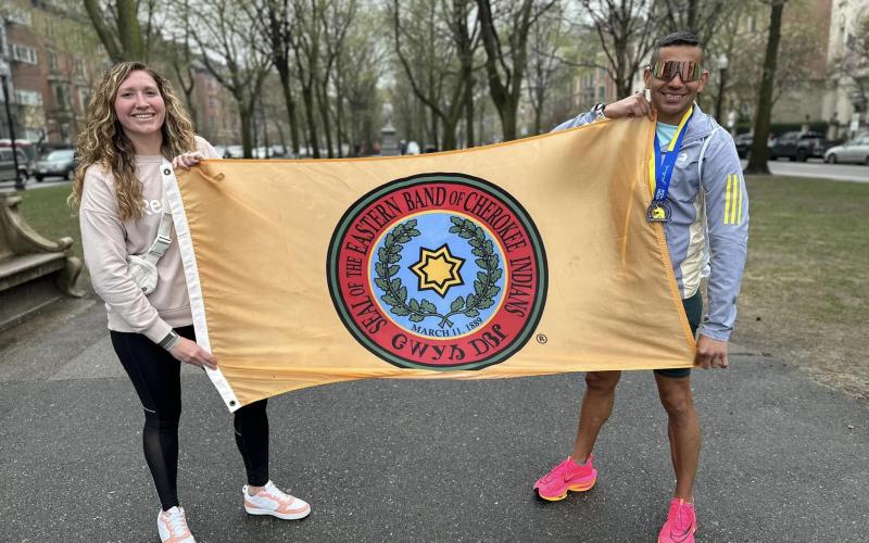 From left, Katelynn Ledford-McCoy and Kallup McCoy hold up the Eastern Band of Cherokee Indians flag while visiting Boston for the 127th Boston Marathon.