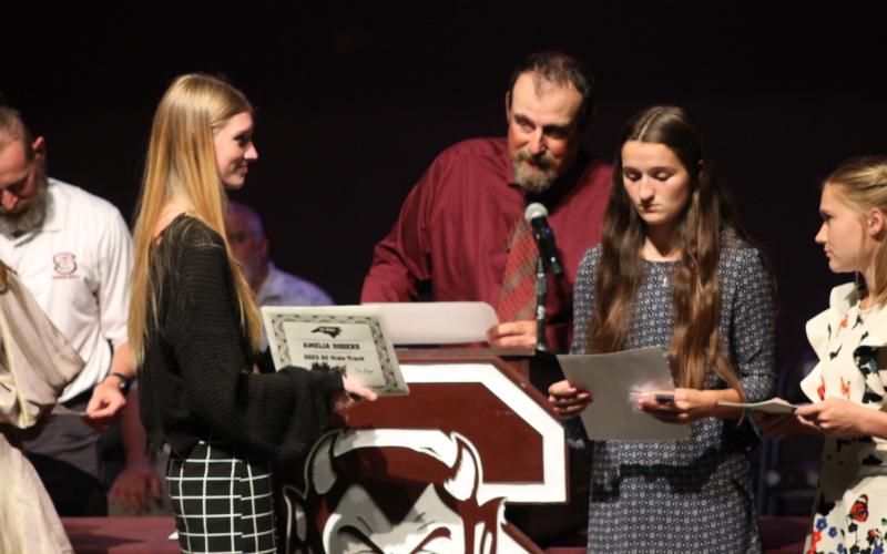 Amelia Rogers (from left), Cora Watkins and Annie Lewis on stage for track at the Athletic Awards ceremony May 24.
