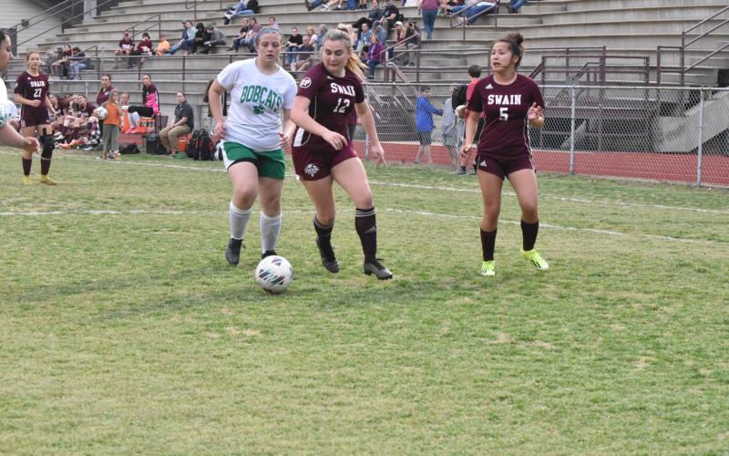 Junior Lola Collins (center) fights for the ball at the soccer game Tuesday, April 2 against Blue Ridge.